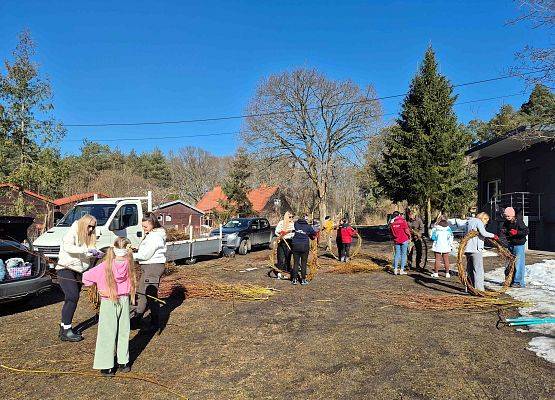 Zdjęcie przedstawia kilka osób wyplatających gniazda.