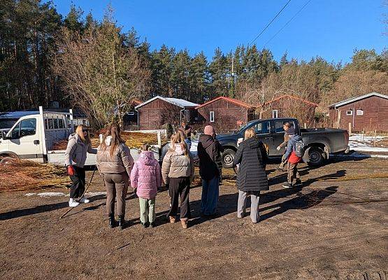 Grupa ludzi stojących na placu omawia zasady bezpieczeństwa.